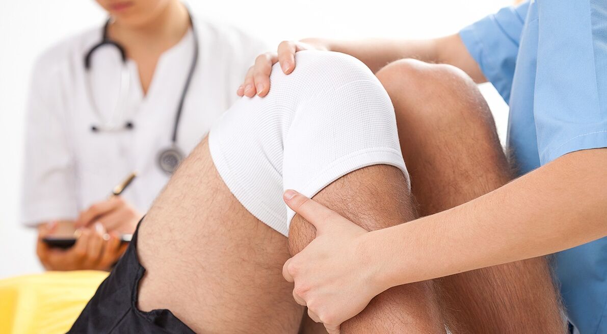 the doctor examines the knee with arthrosis